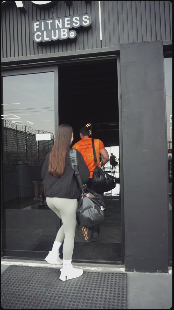 Persona ejecutando abducción de cadera en máquina, ejercicio de tonificación para glúteos en gimnasio.