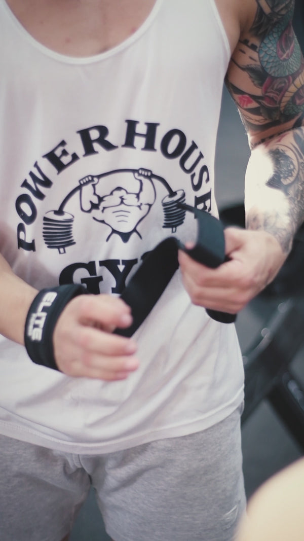 Hombre ejecutando extensión de tríceps en polea alta con cuerda, ejercicio de definición para brazos en gimnasio.