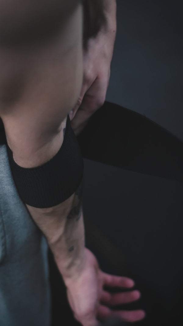 Hombre ejecutando extensión de tríceps en polea alta con cuerda, ejercicio de definición para brazos en gimnasio.